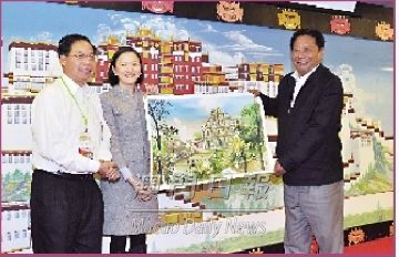 Oferta de lembrança por Zhong Yi Seabra de Mascarenhas e Lai Ieng a Nyima Tsering (direita)