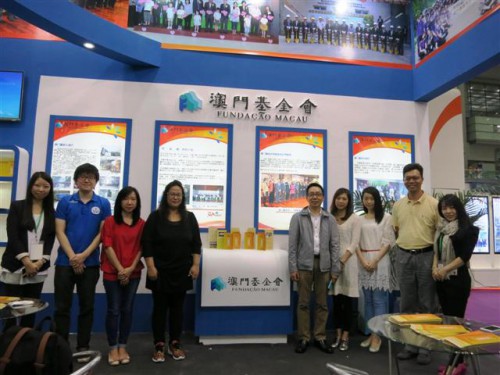 Fotografia dos representantes da Fundação Macau e de diversas instituições de carácter filantrópico e social de Macau em frente aos standes de exposição de Macau
