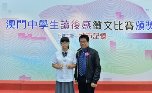 O Director Editorial Substituto do Jornal Ou Mun, Dr. Chui Chi Tou, entregou o prémio a Ho Ian Ian, 1.º classificado do Grupo de Escolaridade do 7.º ao 9.º ano.