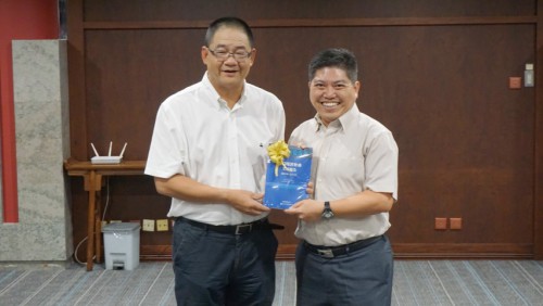 Editor principal, Dr. Wu Zhiliang, oferece o Livro Azul ao Chefe Funcional da Biblioteca da Universidade de Macau, Dr. Leong Tak Hoi